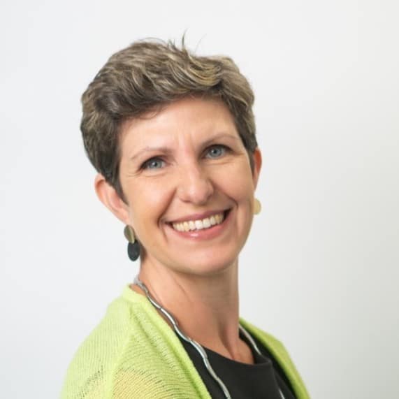 Federica Ronco Smiling woman with short hair wearing a green top and black necklace.