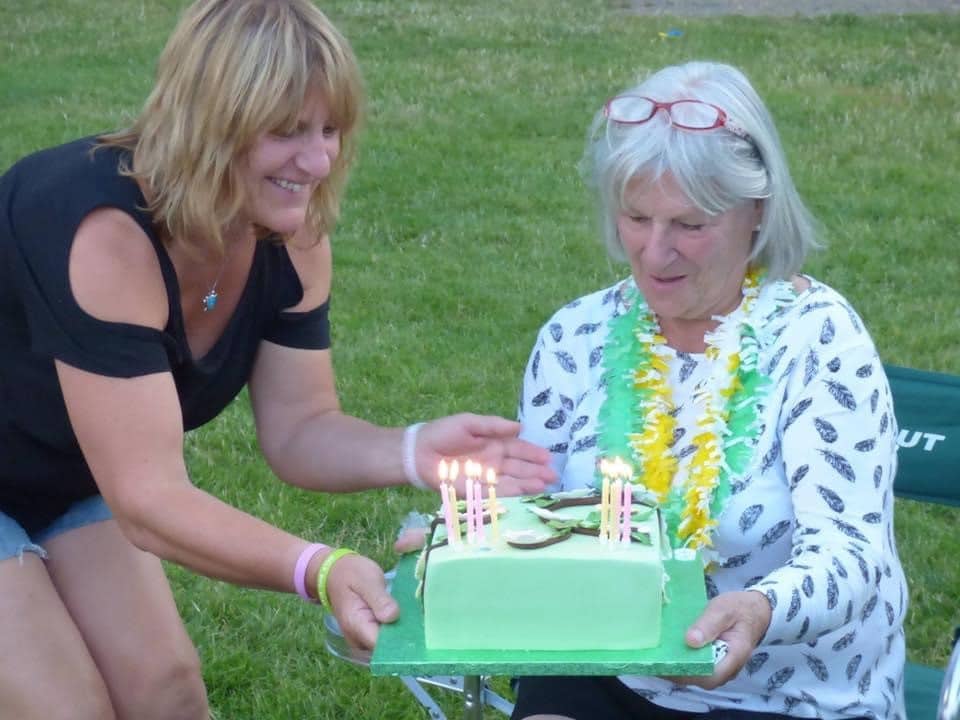 SHIRLE~2 Shirley and her mother, Lynnie, outdoors with a green cake topped with candles.
